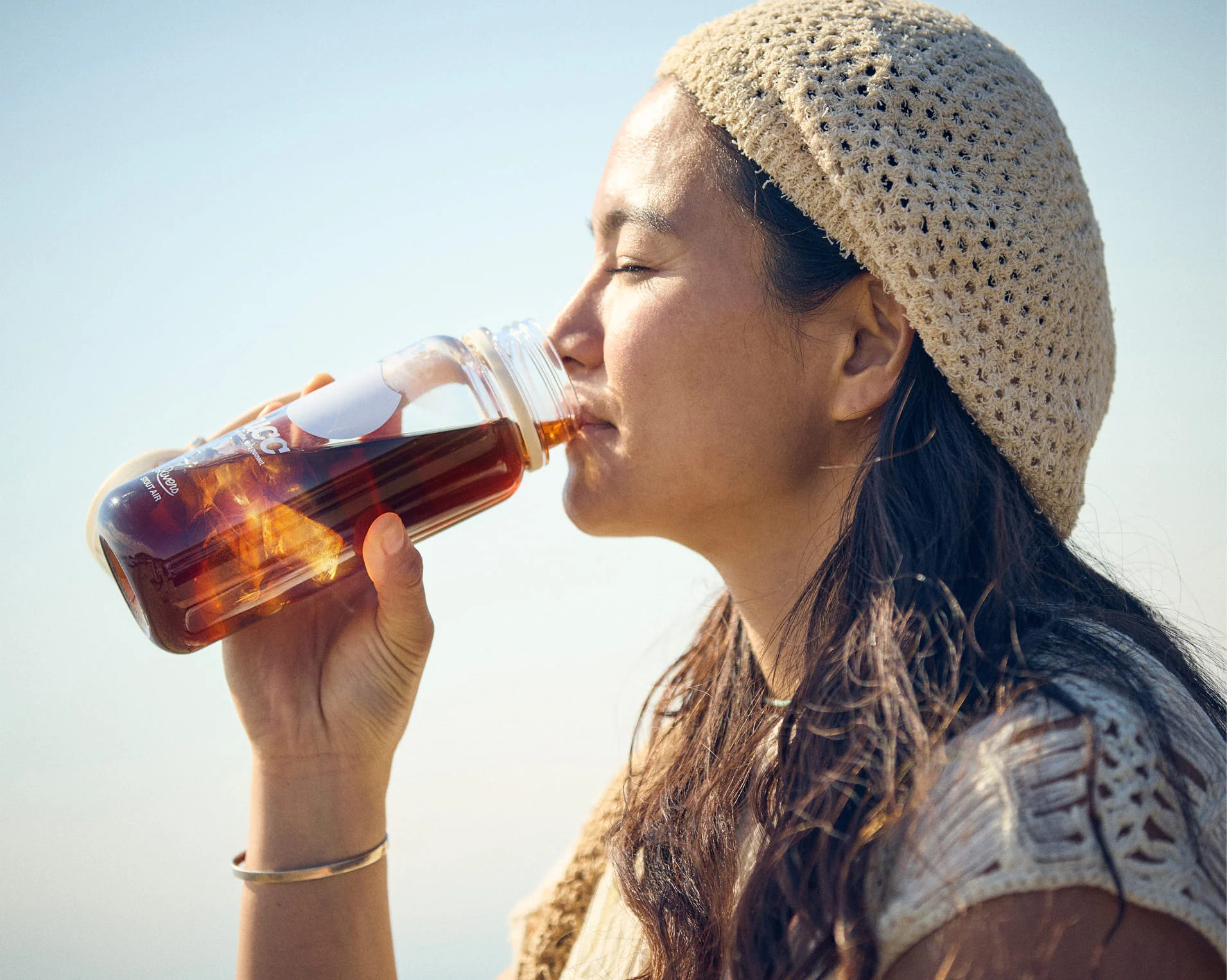 屋外でコーヒーを飲む女性の写真
